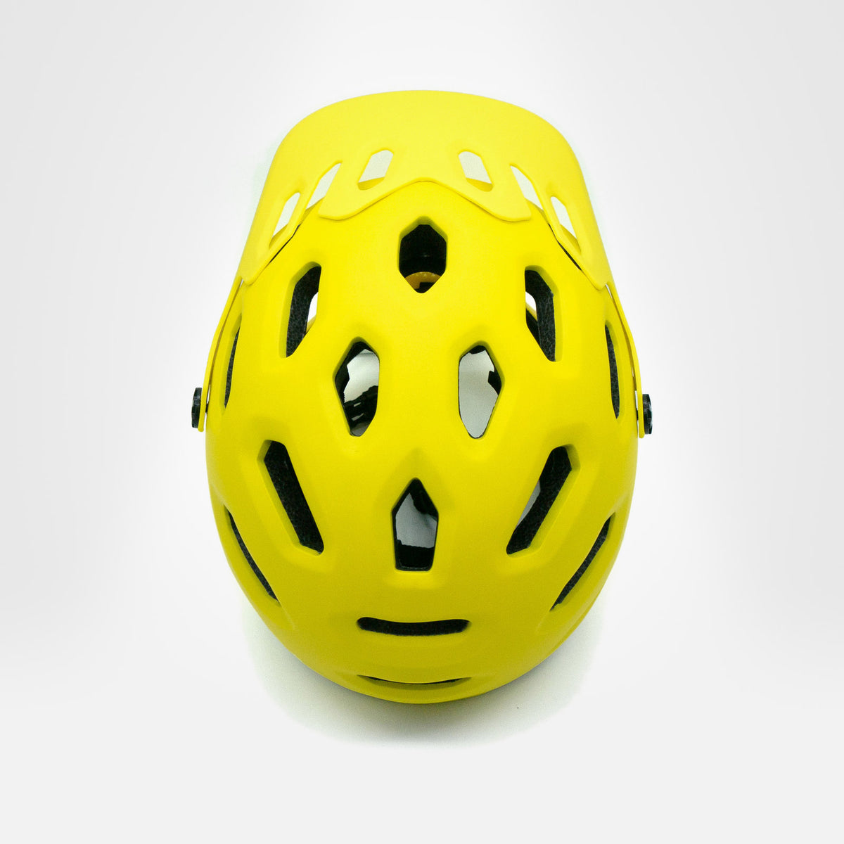 Żółty kask MOTUS MTB z góry: układ otworów wentylacyjnych w skorupie.