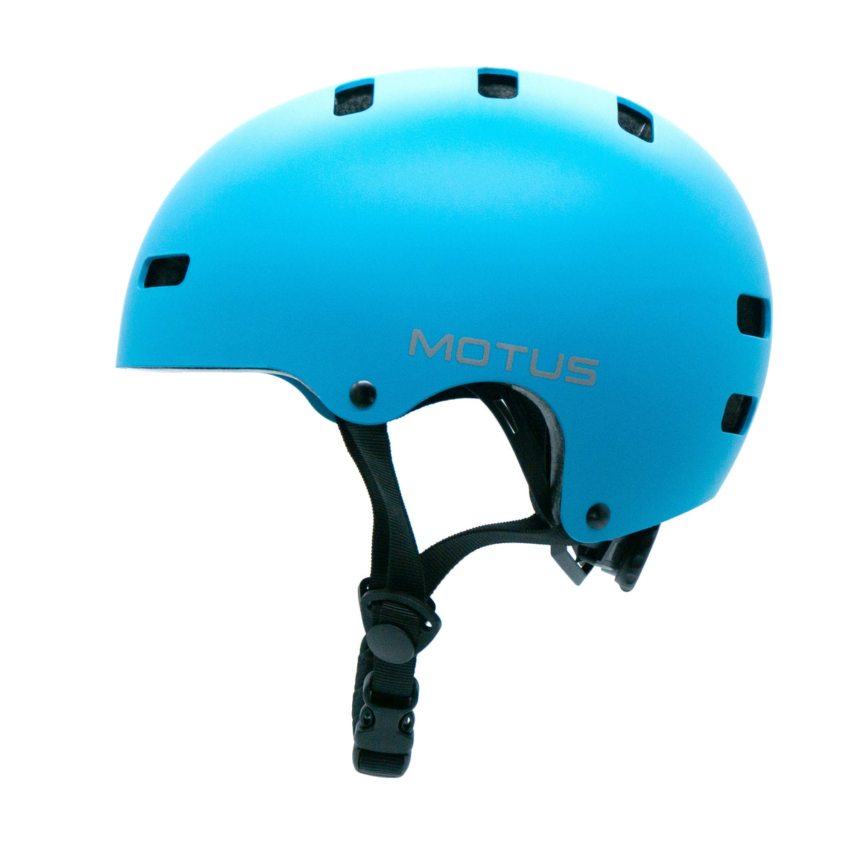Kask dziecięcy MOTUS niebieski, widok z lewego boku: gładka skorupa bez daszka, szare logo MOTUS, czarne paski i klamra pod brodą.