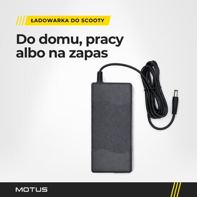 Ładowarka Motus Scooty w jasnym studiu, widok z góry: czarny zasilacz z falistym żebrowaniem i przewód spięty gumką.