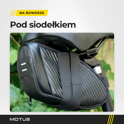 Torba pod siodełko MOTUS zamocowana pod siodełkiem roweru: paski na rzep na szynach siodełka i 2 jasne paski z tyłu.