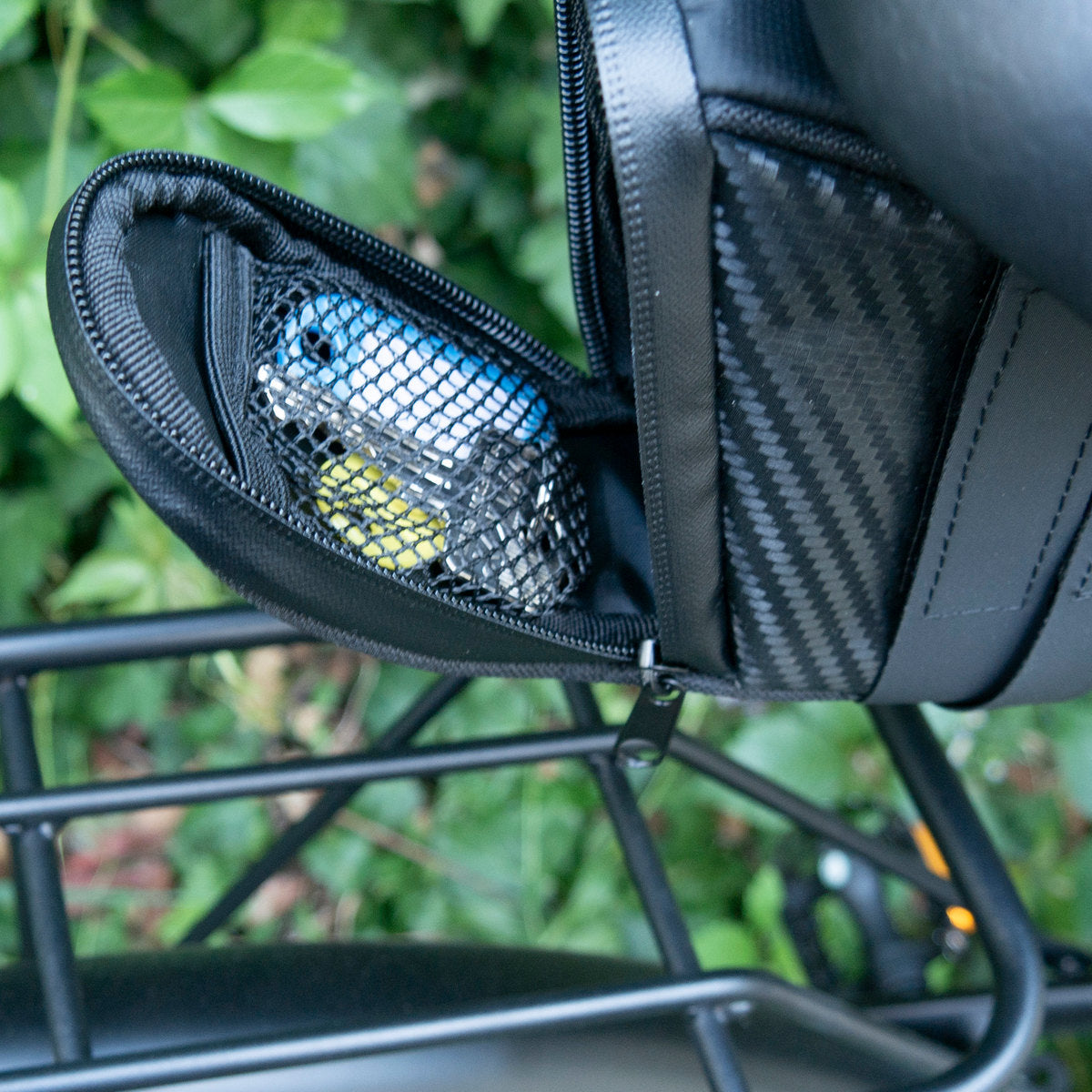 Odchylona klapa torby pod siodełko MOTUS z kieszenią z siatki, torba zamocowana pod siodełkiem roweru.
