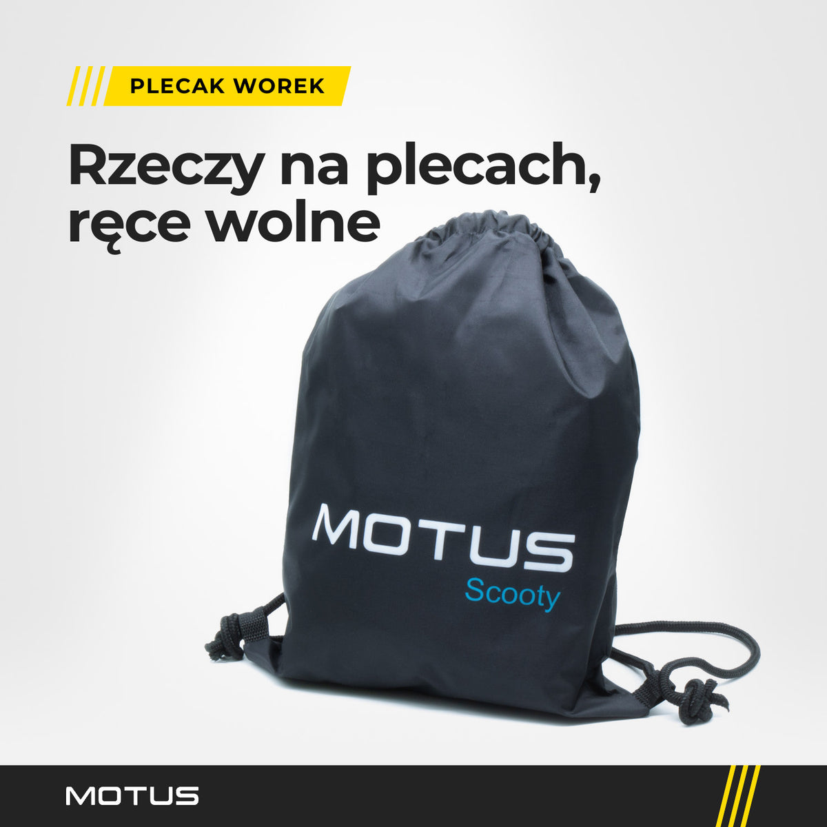 Czarny plecak worek MOTUS Scooty stojący w jasnym studiu, widziany z ukosa: białe logo, ściągnięty kanał i sznurki zawiązane w pętlach rogów.