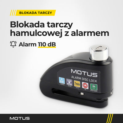 Blokada tarczy z alarmem MOTUS Alarm Lock w jasnym studiu, widok 3/4: obudowa z naklejką MOTUS, srebrna wkładka zamka i szczelina na tarczę.